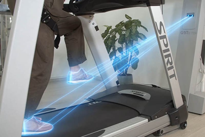 GaitBetter's virtual reality technology for gait training and fall prevention is shown reading and calibrating the gait of an elderly patient as she walks on the VR treadmill in a physical therapy center