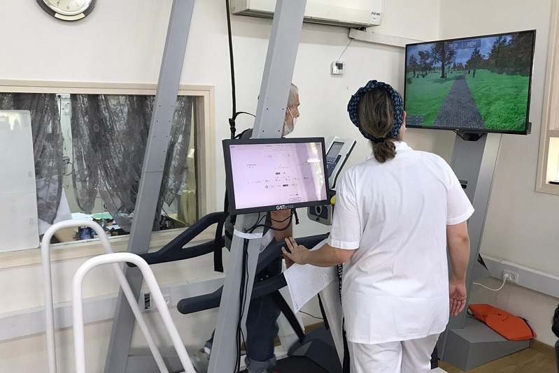 A physical therapist provides a patient therapy session on a VR treadmill solution using GaitBetter's virtual reality gait training and fall prevention intervention